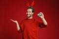 Young man wearing deer horns showing credit card and copyspace Royalty Free Stock Photo