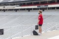 A young man wearing a face mask and jersey in school colors looks out over the empty football stadium at the University of Georgia Royalty Free Stock Photo