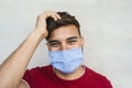 Young man wearing face mask portrait - Latin boy using protective facemask for preventing spread of corona virus Royalty Free Stock Photo