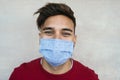 Young man wearing face mask portrait - Latin boy using protective facemask for preventing spread of corona virus Royalty Free Stock Photo