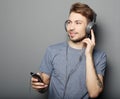 Young man wearing headphones and holding mobile phone Royalty Free Stock Photo