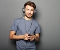 Young man wearing headphones and holding mobile phone Royalty Free Stock Photo