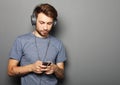 Young man wearing headphones and holding mobile phone Royalty Free Stock Photo