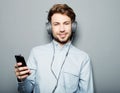 Young man wearing headphones and holding mobile phone Royalty Free Stock Photo