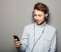 Young man wearing headphones and holding mobile phone Royalty Free Stock Photo