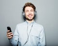 Young man wearing headphones and holding mobile phone Royalty Free Stock Photo