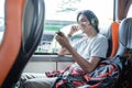 a young man wearing headphones while listening music from a handphone while sitting Royalty Free Stock Photo