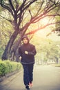 Young man wearing hood jacket running on urban street