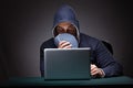 Young man wearing a hoodie sitting in front of a laptop computer Royalty Free Stock Photo