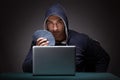 Young man wearing a hoodie sitting in front of a laptop computer Royalty Free Stock Photo