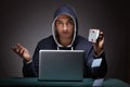 Young man wearing a hoodie sitting in front of a laptop computer Royalty Free Stock Photo