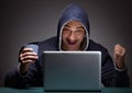 Young man wearing a hoodie sitting in front of a laptop computer Royalty Free Stock Photo