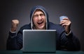 Young man wearing a hoodie sitting in front of a laptop computer Royalty Free Stock Photo