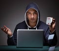 Young man wearing a hoodie sitting in front of a laptop computer Royalty Free Stock Photo