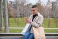 Young man wearing make up holding shopping bags and chatting on smartphone. Royalty Free Stock Photo