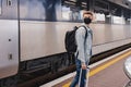 Young man wearing protective face mask standing on the railway station near the train Royalty Free Stock Photo