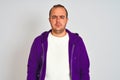 Young man wearing purple sweatshirt standing over isolated white background depressed and worry for distress, crying angry and Royalty Free Stock Photo