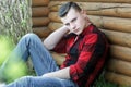 Young man wearing red checked shirt and jeans outdoor portrait