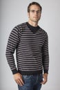 Young man wearing striped sweater, denim jeans and eyeglasses. Men`s casual fall clothing apparel fashions styles.