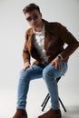 Young man wearing sunglasses and leather jacket sitting Royalty Free Stock Photo