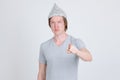 Young man wearing tin foil hat as conspiracy theory concept pointing at camera