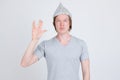 Young man wearing tin foil hat as conspiracy theory concept showing Vulcan salute in Star Trek