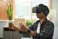 Man wearing virtual reality glasses and enjoying playing driving simulation video game.