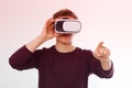 Young Man wearing virtual reality goggles and toch space by finger isolated on white background. VR concept and copy space.