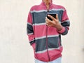 Young man wearing warm clothes using smart phone. Royalty Free Stock Photo