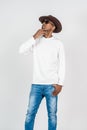 A young man wearing white blank long sleeve shirt, with glasses and a hat doing a pose with thinking gesture Royalty Free Stock Photo