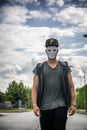 Young man wearing white creepy mask outdoor in city street Royalty Free Stock Photo