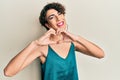 Young man wearing woman make up wearing party clothes smiling in love doing heart symbol shape with hands Royalty Free Stock Photo