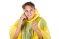 Young man wearing a yellow raincoat calling a taxi Royalty Free Stock Photo