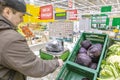 A young man weighs goods on an electronic self-service scale in the vegetable department of a chain hypermarket. Royalty Free Stock Photo