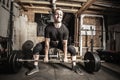 Young man weight training in a gritty basement gym