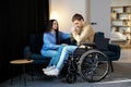 Young man in a wheelchair. Girlfriend comforting her sad boyfriend