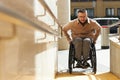 Man in wheelchair moving up the ramp Royalty Free Stock Photo