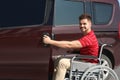 Young man in wheelchair opening door of his van Royalty Free Stock Photo