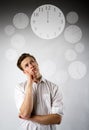 Young man in white and clock. Time is passing Royalty Free Stock Photo