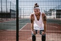 Young man with white headband on his head and tattoos on his arms dressed in the white t-shirt, black leggings and blue Royalty Free Stock Photo