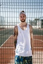 Young man with white headband on his head and tattoos on his arms dressed in the white t-shirt, black leggings and blue Royalty Free Stock Photo