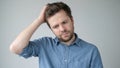 Young man with white shirt having doubts and with confuse face expression Royalty Free Stock Photo