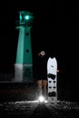 Young man with a white splitboard stands on the sand against the background of a glowing pendulum Royalty Free Stock Photo