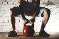 Young man in a white t-shirt holding a red kettlebell Royalty Free Stock Photo