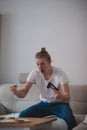 Young man in a white T-shirt and a pigtail on his head rejoices in the game console won in his living room. The concept of e- Royalty Free Stock Photo