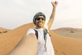 young man in white tshirt in desert, treveling in UAE on safari, wearing hat and backpack, exploring nature of sandy beauty.