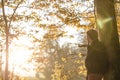 Young man in winter jacket leaning on a tree trunk Royalty Free Stock Photo