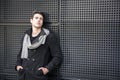 Young Man in a Winter Outfit Leaning on Metal Wall