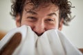 A young man wipes his face after shaving at the bathroom. Routine, morning, hygiene Royalty Free Stock Photo