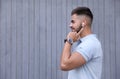 Young man with wireless headphones listening to music near wall. Space for text Royalty Free Stock Photo